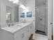 Bathroom featuring dual vanity with quartz countertop and glass enclosed shower at 6602 S Sherrill St, Tampa, FL 33616