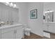 White bathroom features a modern vanity, toilet, and a well-lit mirror at 6602 S Sherrill St, Tampa, FL 33616