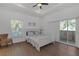 Cozy bedroom featuring wood floors, a tray ceiling, and access to a balcony at 6602 S Sherrill St, Tampa, FL 33616