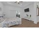 Comfortable bedroom with wood flooring, TV, tray ceiling, and sliding glass door to the balcony at 6602 S Sherrill St, Tampa, FL 33616