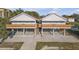 A street-level exterior of this two-story light gray home with a brown roof, concrete driveway and wooden deck at 6602 S Sherrill St, Tampa, FL 33616