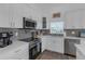 Modern kitchen features stainless appliances, quartz counters, and gray backsplash tiles at 6602 S Sherrill St, Tampa, FL 33616