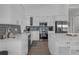 Bright modern kitchen featuring white cabinetry, gray backsplash, stainless appliances, and a large center island at 6602 S Sherrill St, Tampa, FL 33616
