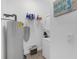 Functional laundry area features a stacked washer/dryer, water heater and shelving for storage at 6602 S Sherrill St, Tampa, FL 33616