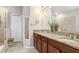 Elegant bathroom featuring granite countertops, double sinks, and modern fixtures with neutral tiling at 6620 Paden Wheel St, Zephyrhills, FL 33541