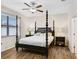 Bright main bedroom with a four-poster bed, wood floors, ceiling fan, and plenty of natural light at 6620 Paden Wheel St, Zephyrhills, FL 33541