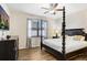 Spacious main bedroom with a four-poster bed, ceiling fan, wood flooring and large windows at 6620 Paden Wheel St, Zephyrhills, FL 33541