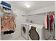 Bright laundry room with washer, dryer, and ample shelving for storage at 700 Starkey Rd # 311, Largo, FL 33771