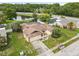 An aerial view of the house with the pond and trees surrounding the property at 7018 Arbor View Ln, New Port Richey, FL 34653