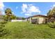 View of the side yard featuring a lawn, partial fence and mature palm tree at 7018 Arbor View Ln, New Port Richey, FL 34653