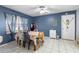 Dining room with tile flooring, blue accent wall, floral tablecloth and chair covers, and a ceiling fan at 7018 Arbor View Ln, New Port Richey, FL 34653