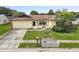 A cozy single-Gathering home featuring a driveway, garage, and mature landscaping at 7018 Arbor View Ln, New Port Richey, FL 34653