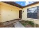 Exterior shot of front door showing a small porch, storm door and adjacent window at 7018 Arbor View Ln, New Port Richey, FL 34653