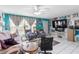 Living room with a ceiling fan and a large television at 7018 Arbor View Ln, New Port Richey, FL 34653