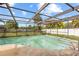 Screened-in swimming pool featuring a concrete deck and surrounded by tropical foliage at 7018 Arbor View Ln, New Port Richey, FL 34653
