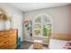 Bright secondary bedroom with arched window, a dresser, a daybed, and ample natural light at 852 Crystal Dr, Palm Harbor, FL 34683