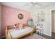 Cozy secondary bedroom with unique decor, a white ceiling fan, a daybed, and a white desk at 852 Crystal Dr, Palm Harbor, FL 34683