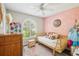Charming secondary bedroom with bright decor, a white ceiling fan, a daybed, and a modern window at 852 Crystal Dr, Palm Harbor, FL 34683