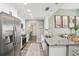 Bright kitchen featuring white cabinets, stainless steel appliances, and granite countertops at 852 Crystal Dr, Palm Harbor, FL 34683