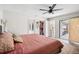 Spacious main bedroom features a ceiling fan, a decorative rug, closet, and access to the screened lanai at 852 Crystal Dr, Palm Harbor, FL 34683