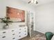 Home office with white dresser, palm tree painting and wood-look floors at 852 Crystal Dr, Palm Harbor, FL 34683