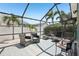 Screened-in patio area with stylish furniture and lush landscaping at 852 Crystal Dr, Palm Harbor, FL 34683