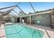 In-ground pool surrounded by the screened-in patio at 852 Crystal Dr, Palm Harbor, FL 34683
