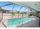 Screened-in pool with palm trees and lounge chairs at 852 Crystal Dr, Palm Harbor, FL 34683