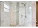 Stylish walk-in shower with gray and white tile surround, integrated shelves, and glass door at 852 Crystal Dr, Palm Harbor, FL 34683