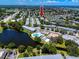 Overhead view of a condo community with a pool, clubhouse, and scenic pond surrounded by mature trees at 8584 111Th St # 308, Seminole, FL 33772