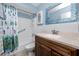 Well-lit bathroom featuring a tub with shower, updated vanity with countertop, and a decorative fish themed shower curtain at 8584 111Th St # 308, Seminole, FL 33772