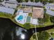Aerial view of the community pool next to a lake featuring lounge chairs, recreation areas, and lush greenery at 8584 111Th St # 308, Seminole, FL 33772