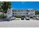 Condominium building with parking and multiple balconies under a clear blue sky at 8584 111Th St # 308, Seminole, FL 33772