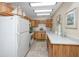 Efficient kitchen layout with white appliances, ample counter space, and natural wood cabinetry at 8584 111Th St # 308, Seminole, FL 33772