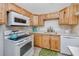Cozy kitchen featuring wood cabinets, white appliances, and a bright countertop at 8584 111Th St # 308, Seminole, FL 33772