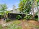 Lush backyard featuring mature trees and a covered patio, ideal for outdoor enjoyment and privacy at 8731 Huntfield St, Tampa, FL 33635