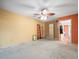 Bedroom with ceiling fan and orange accent wall, showcasing the open layout and neutral finishes at 8731 Huntfield St, Tampa, FL 33635