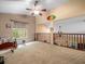 Open loft with carpet flooring, railings, and natural light at 8731 Huntfield St, Tampa, FL 33635