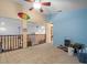 Spacious loft with carpet flooring, natural light, and railing at 8731 Huntfield St, Tampa, FL 33635