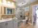 Bathroom features a white vanity with double sinks, a decorative mirror, and a walk-in shower with marble surround at 9702 Mary Robin Dr, Riverview, FL 33569