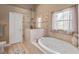 Luxurious bathroom showcasing a soaking tub, tiled shower, and bright lighting at 9702 Mary Robin Dr, Riverview, FL 33569