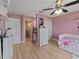 Bright bedroom with a ceiling fan, wood floors, a white dresser, a bed, and access to an en-suite bathroom at 9702 Mary Robin Dr, Riverview, FL 33569