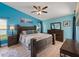 Serene bedroom with blue walls, wood furniture, a ceiling fan, and ample natural light at 9702 Mary Robin Dr, Riverview, FL 33569