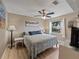 Bedroom features a ceiling fan, wood floors, a queen bed, a window, and a nightstand with a lamp at 9702 Mary Robin Dr, Riverview, FL 33569
