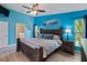 Bedroom with light blue walls, wood furniture, a ceiling fan, and a view into the bathroom at 9702 Mary Robin Dr, Riverview, FL 33569