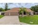 Charming single-story home featuring a well-manicured lawn and three-car garage at 9702 Mary Robin Dr, Riverview, FL 33569