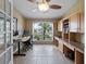 Well-lit home office featuring custom built-ins, a workspace, a ceiling fan, and a large window at 9702 Mary Robin Dr, Riverview, FL 33569