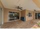 Covered patio area with brick flooring, ceiling fans, and sliding glass doors leading to the screened in pool at 9702 Mary Robin Dr, Riverview, FL 33569