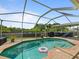Backyard screened-in pool with brick patio, lawn, and view of the covered lanai is perfect for Gathering fun at 9702 Mary Robin Dr, Riverview, FL 33569