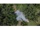 An aerial view of a home with a light colored roof surrounded by many trees at 1110 Mercer Loop, Plant City, FL 33567
